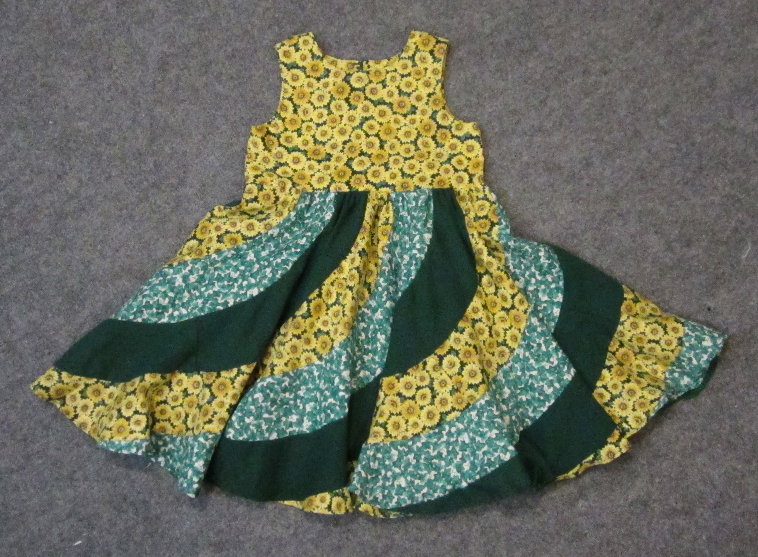 Green and yellow sunflower sleeveless spiral dress for a young girl